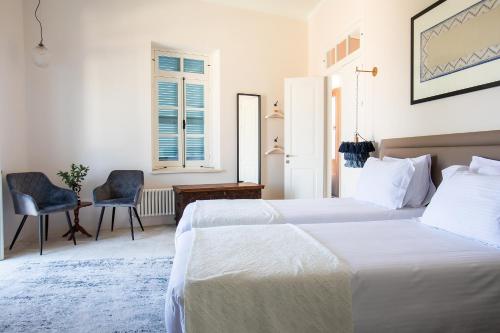 a bedroom with two beds and a desk and a chair at House 1923 Boutique Hotel in Pano Lefkara