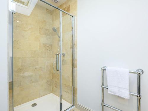 a shower stall with a glass door in a bathroom at Barn End Cottage in Kelsale