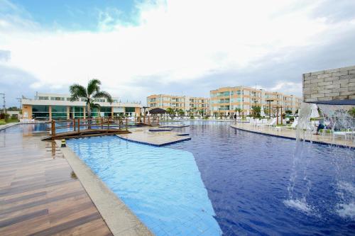 ein Schwimmbecken mit einem Springbrunnen in der Mitte in der Unterkunft Flat Sun House Muro Alto - Conforto e Estrutura de Resort in Ipojuca