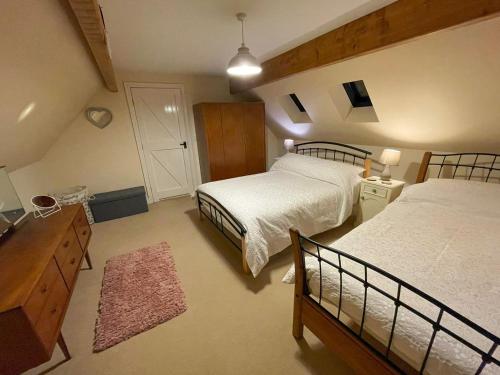 een grote slaapkamer met 2 bedden en een dressoir en een dressoir bij Beech Cottage in Rhewl