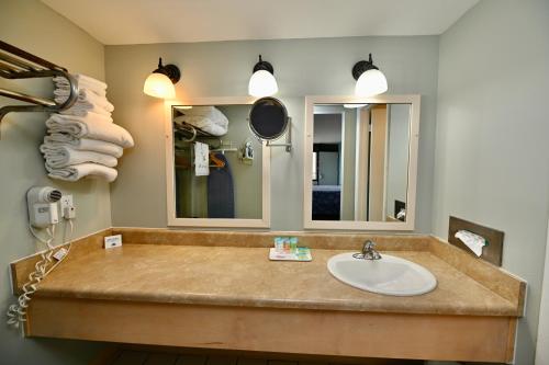 La salle de bains est pourvue d'un lavabo et d'un miroir. dans l'établissement Buccaneer Inn, à Île Saint Georges