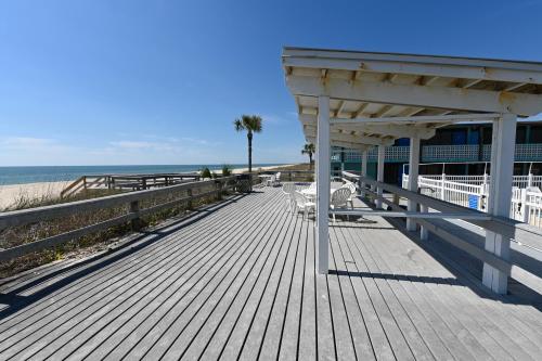 a wooden boardwalk with a pavilion on the beach at Buccaneer Inn in St. George Island