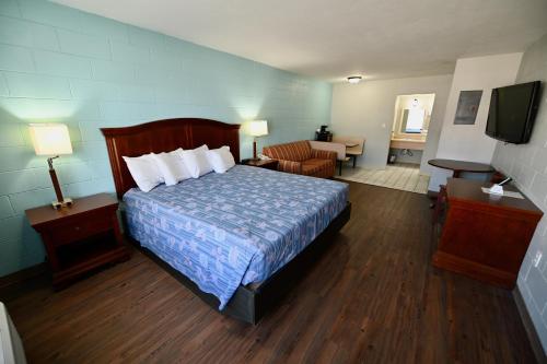 une chambre d'hôtel avec un lit et un salon dans l'établissement Buccaneer Inn, à Île Saint Georges