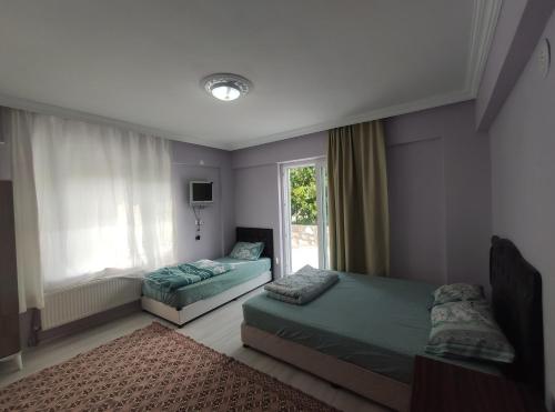 a bedroom with two beds and a window at Kaplan Apart - Pansiyon in Yeşilova