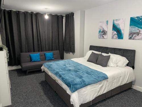South Norwood的住宿－Modern 4 Bedroom House 10 mins from East Croydon with Garden and Free parking，一间卧室配有一张大床和一张沙发