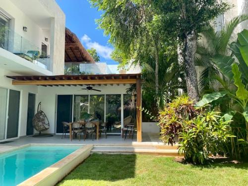 a house with a swimming pool and a dining room at Luxury Private Villas , Private Pool, Private garden, Jacuzzi, 24hours security in Tulum