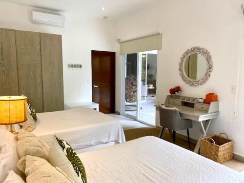 a bedroom with two beds and a desk and a mirror at Luxury Private Villas , Private Pool, Private garden, Jacuzzi, 24hours security in Tulum