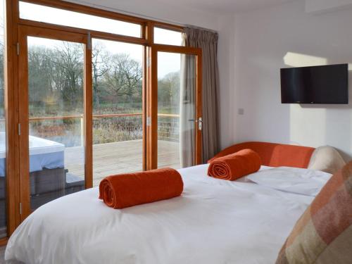 a bedroom with a bed with orange towels on it at Waterside Lodge Sixteen - Uk13038 in Southowram