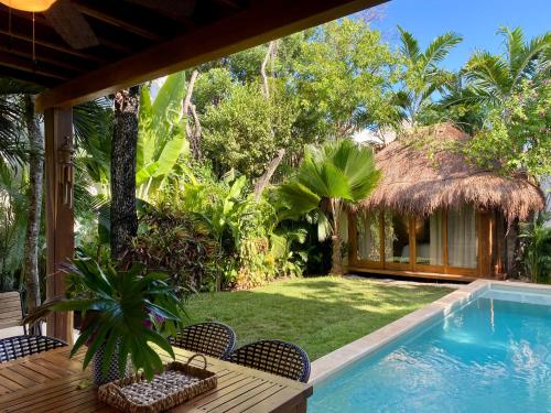 a backyard with a swimming pool and a resort at Luxury Private Villas , Private Pool, Private garden, Jacuzzi, 24hours security in Tulum