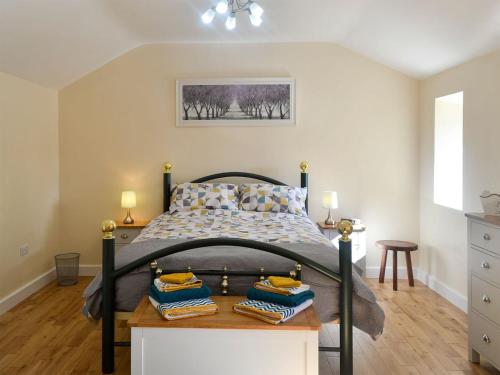 a bedroom with a bed and a table with towels at Penrhos Bach in Llanerchymedd