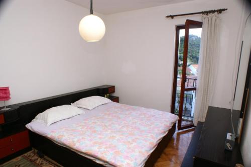 sypialnia z łóżkiem i drzwiami prowadzącymi na balkon w obiekcie Apartment Zrnovska Banja 3154a w Korčuli
