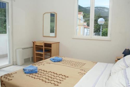 1 dormitorio con 1 cama con 2 toallas azules en Apartments and rooms by the sea Zuljana, Peljesac - 3164 en Žuljana