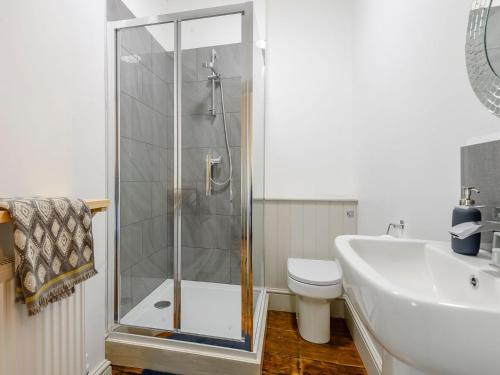 y baño con ducha, aseo y lavamanos. en Colveston Manor en Cranwich