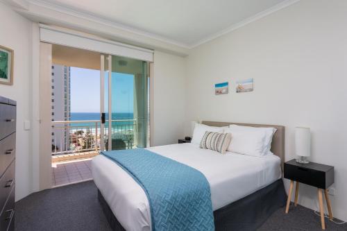 a bedroom with a large bed and a balcony at Maldives Resort Main Beach, Gold Coast in Gold Coast