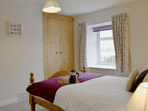 a bedroom with a bed and a window at Parkside Cottage in Frizington
