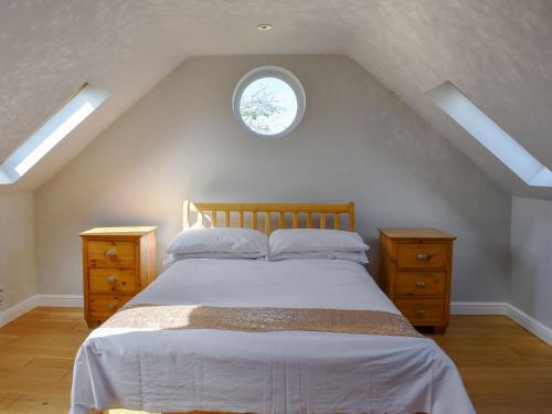 Stretham的住宿－Hill Farm Cottage，一间卧室设有一张大床和一个窗户。
