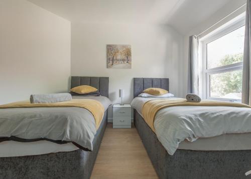 a bedroom with two beds and a window at Ryland House Sleeps 8 M6 Access & Garden in Birmingham