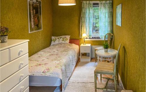 um quarto com uma cama, uma mesa e uma cadeira em Stunning Home In Hultsfred With Kitchen em Hultsfred