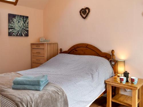 a bedroom with a bed with a blue towel on it at Heron Cottage in Lossiemouth