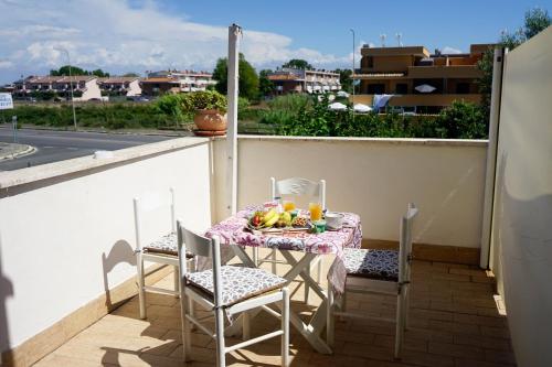 a table and chairs on a balcony with a meal on it at Casa Donna di Cuori in Fiumicino