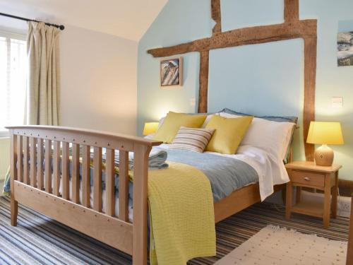 a bedroom with a bed and a crib at Cenwulf Cottage in Winchcombe