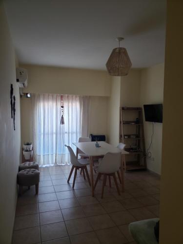 ein Wohnzimmer mit einem Tisch, Stühlen und einem TV in der Unterkunft Excelente departamento en zona céntrica. C/Cochera in Río Cuarto