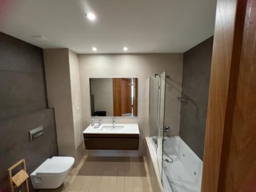 a bathroom with a sink and a shower and a toilet at Rocha Prime - Standing apartment T3 in Portimão