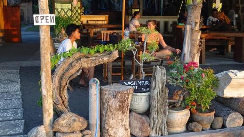 a group of people sitting at a table with plants at Gede Homestay in Lovina