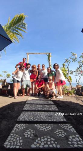 a group of people posing for a picture on a beach at Gede Homestay in Lovina