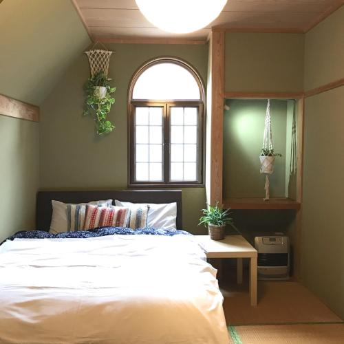 a bedroom with a large bed and a window at A short walk to Akakura Onsen Ski Lift and Town by Japow House in Myoko