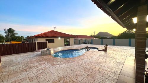 a swimming pool in the middle of a patio at Enjoyment Villa Cataleya in Oranjestad