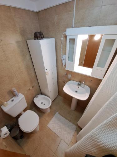 a bathroom with a sink and a toilet and a mirror at Paraná Confort in Paraná