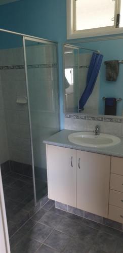 a bathroom with a sink and a glass shower at The Heights Bed & Breakfast in Jurien Bay