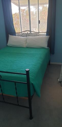 a green bed with a window in a room at The Heights Bed & Breakfast in Jurien Bay