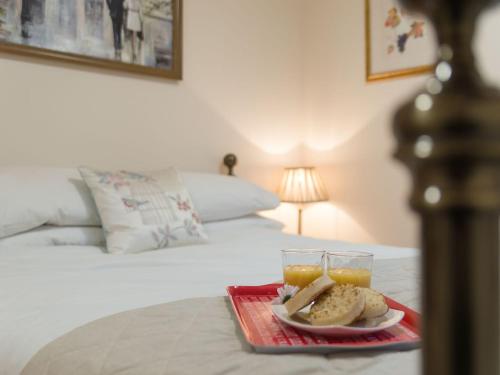 a tray of bread and two glasses of orange juice on a bed at Kingfisher Cottage in Wainfleet All Saints