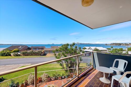 a balcony with chairs and a view of the ocean at Triview Mitchell Street Unit 4 1 Soldiers Point in Soldiers Point