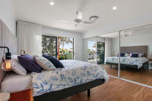 een slaapkamer met een bed en een grote spiegel bij Lake House On Magellan 58 Ramsay Crescent in Golden Beach