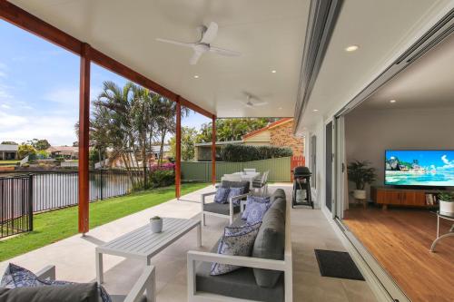 a living room with a couch and a tv on a patio at Lake House On Magellan 58 Ramsay Crescent in Golden Beach