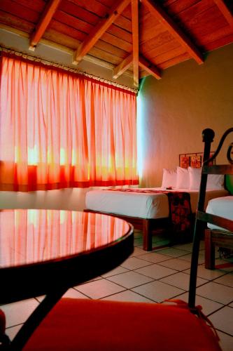 a bedroom with two beds and a window at Hotel Aldama in Colima