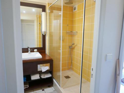 a bathroom with a glass shower and a sink at STUDIO Coquillages&Crustacés in Le Gosier