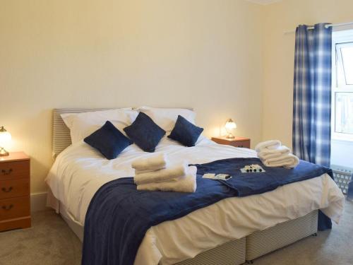 1 dormitorio con 1 cama con toallas en Ardlochan Cottage, en Maidens