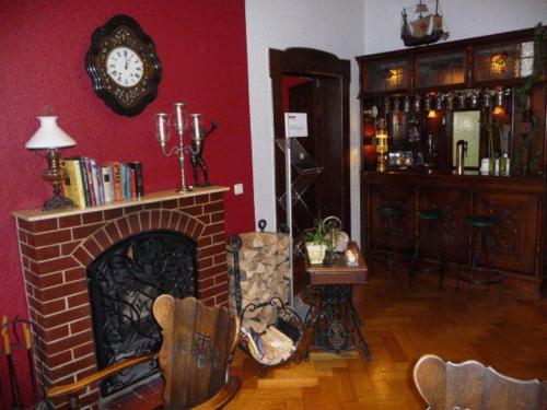 a living room with a fireplace and a clock on the wall at Arthotel ANA Residence Bremen in Bremen