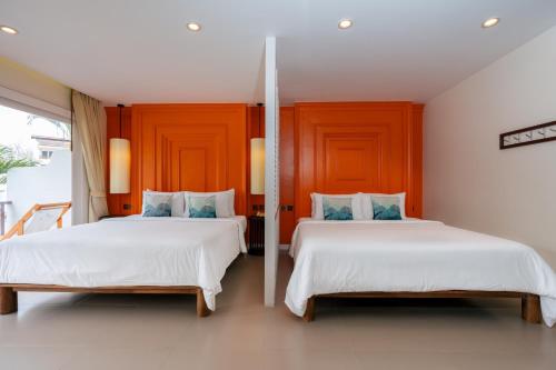 two beds in a room with two beds sidx sidx sidx at Arinara Beach Resort Phuket - SHA Extra Plus in Bang Tao Beach