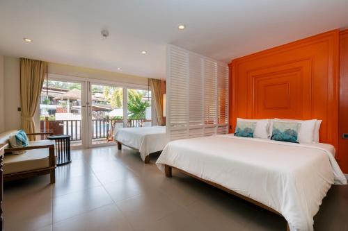 a bedroom with two beds and a balcony at Arinara Beach Resort Phuket - SHA Extra Plus in Bang Tao Beach