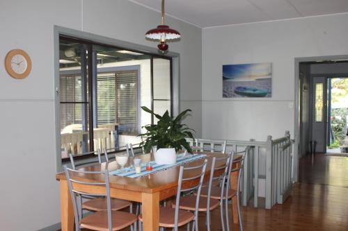una sala da pranzo con tavolo e sedie in legno di Avoca Beach "Cape Cottage" ad Avoca Beach