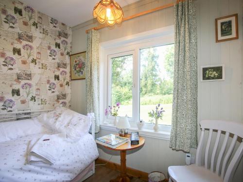 um quarto com uma cama, uma janela e uma mesa em The Garden House - Uk10987 em Llandogo