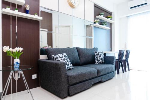ein Wohnzimmer mit einem Sofa und einem Tisch in der Unterkunft NEW 2Br Apartment in Benson Connected to Pakuwon Mall Surabaya Barat in Lontar