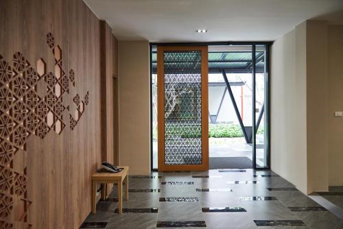 a hallway with a door and a bench in front of it at Almas Hotel Bangkok in Bangkok