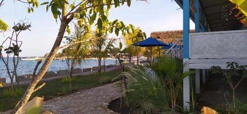 a house with a pathway next to the water at Moyo Island Resort in Moyo Island