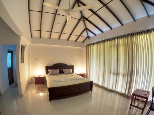 a bedroom with a bed and a large window at Pinnawala Elephant Front View Hotel in Rambukkana